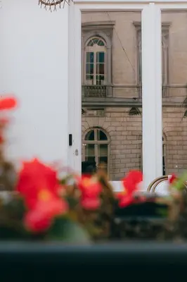 a table with red flowers in front of a building at Kouter House in Ghent