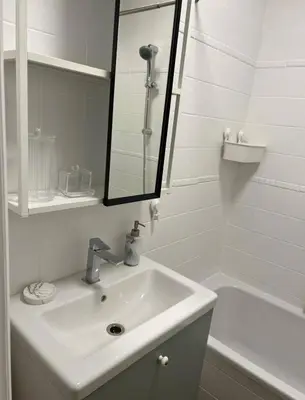 a white bathroom with a sink and a mirror at Beautiful and Cosy Flat in Etterbeek in Brussels