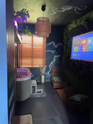 a room with a tv and a wall with a mural at Maison Soleya Brussels, private spa and love room in Asse