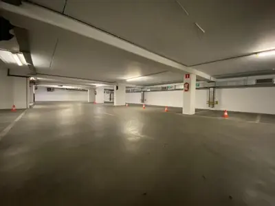 an empty parking garage with orange cones in it at La Perla Appartements Louise in Brussels