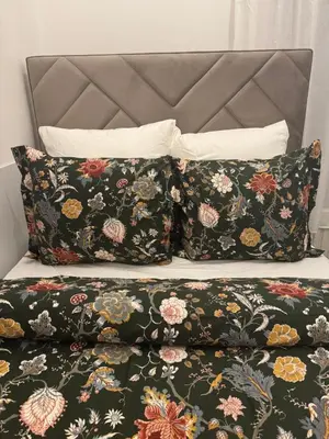 a bed with two pillows on top of it at La Perla Appartements Louise in Brussels