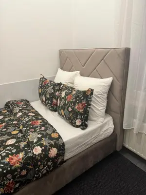 a bed with two pillows on top of it at La Perla Appartements Louise in Brussels