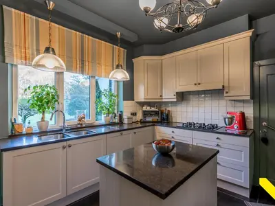 a kitchen with white cabinets and a black counter top at Wezelhoeve in Mol