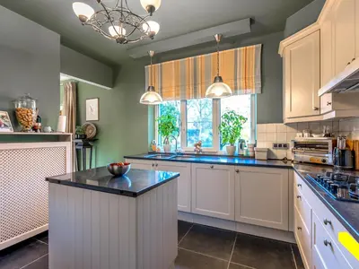 a kitchen with white cabinets and a large window at Wezelhoeve in Mol