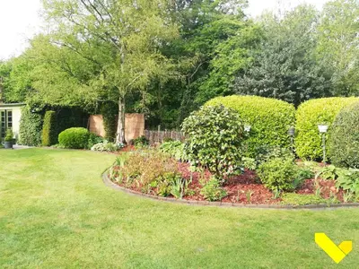 a garden with bushes and flowers in a yard at Wezelhoeve in Mol