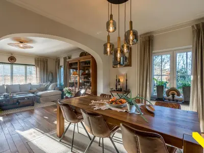 a living room with a large wooden table and chairs at Wezelhoeve in Mol