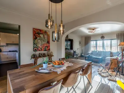 a kitchen and living room with a wooden table and chairs at Wezelhoeve in Mol