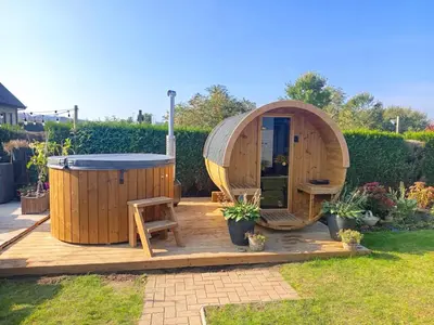 a sauna and a hot tub in a garden at Wezelhoeve in Mol