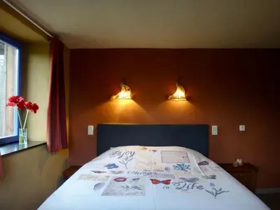 a bedroom with a bed with two lights on the wall at Aan de Jordaan in Boutersem