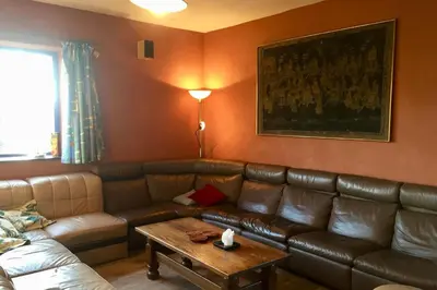 a living room with a leather couch and a table at Aan de Jordaan in Boutersem
