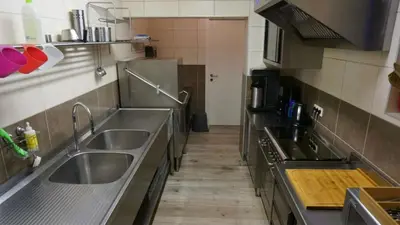 a kitchen with stainless steel counters and stainless steel sinks at Aan de Jordaan in Boutersem
