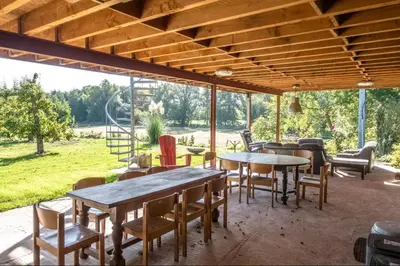 a patio with tables and chairs and a view of a field at Aan de Jordaan in Boutersem