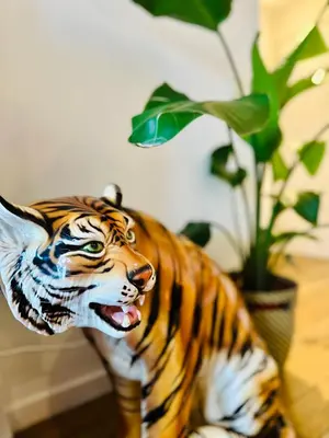 a statue of a tiger sitting next to a potted plant at Antwerp City Nest in Antwerp