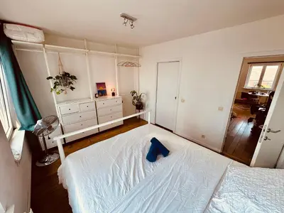 a bedroom with a bed with a blue pillow on it at Antwerp City Nest in Antwerp