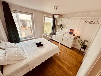 a bedroom with a bed and a large window at Antwerp City Nest in Antwerp