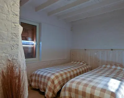 two beds in a room with a window at Relax Ohm in Zottegem