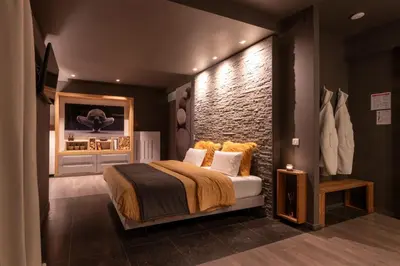 a bedroom with a bed and a brick wall at Relax Ohm in Zottegem