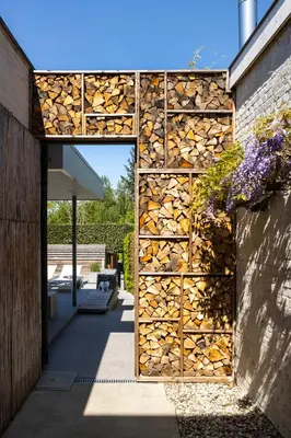 a stack of fire wood is on the side of a building at Relax Ohm in Zottegem