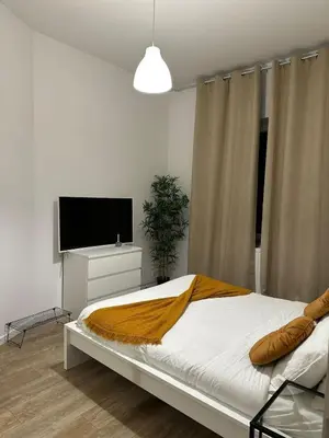 a bedroom with a bed and a flat screen tv at A little love nest in Brussels
