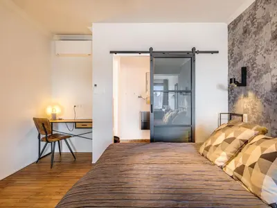 a bedroom with a bed with a glass door at Porta Superia Boutique B&B in Mechelen