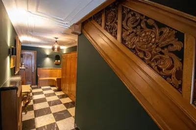 a hallway with a wooden door and a checkered floor at Porta Superia Boutique B&B in Mechelen