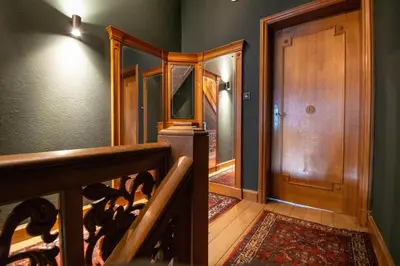a hallway with a staircase and a wooden door at Porta Superia Boutique B&B in Mechelen