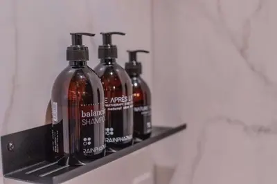 three bottles of soap sitting on a shelf in a bathroom at Porta Superia Boutique B&B in Mechelen