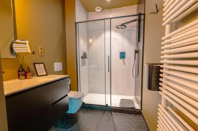 a bathroom with a shower with a glass door at Porta Superia Boutique B&B in Mechelen