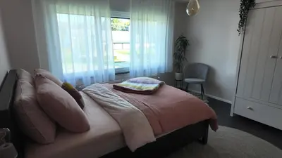a bedroom with a bed with pillows and a window at B&B Sleep140 in Assenede