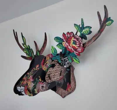 a deer head decoration with flowers on a wall at B&B Sleep140 in Assenede