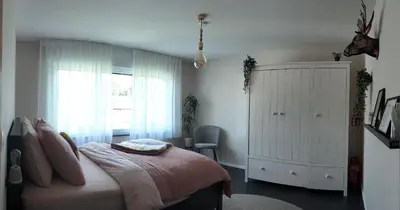 a bedroom with a bed and a dresser and a window at B&B Sleep140 in Assenede