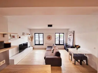 a living room with a couch and a table at Petit cocon au centre de waterloo in Waterloo