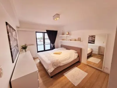 a bedroom with a bed and a large window at Petit cocon au centre de waterloo in Waterloo