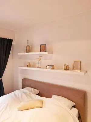a bedroom with a bed and shelves on the wall at Petit cocon au centre de waterloo in Waterloo