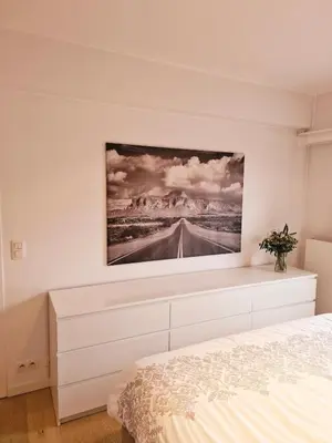 a bedroom with a painting on the wall at Petit cocon au centre de waterloo in Waterloo