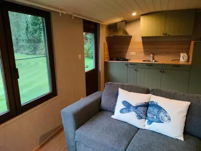 a living room with a couch in a tiny house at Het Karperhuisje in Geel