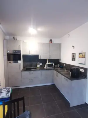 a kitchen with white cabinets and a counter top at collocation en metro erasme in Brussels