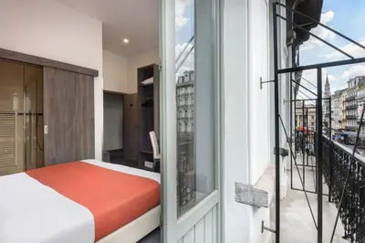 a bedroom with a bed and a balcony at Dansaert Hotel in Brussels