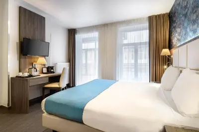 a hotel room with a bed and a desk at Dansaert Hotel in Brussels