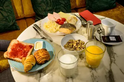 a table topped with plates of breakfast foods and drinks at Dansaert Hotel in Brussels