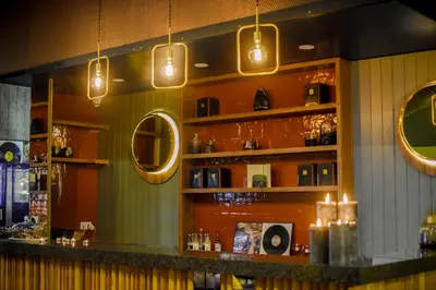 a bar in a restaurant with lights on the wall at Dansaert Hotel in Brussels