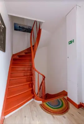 a wooden staircase in a room with a rug at Sweet home in Ghent