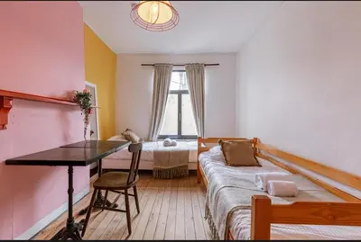 a room with a bed and a desk and a window at Sweet home in Ghent