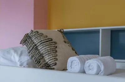 a pillow and towels on top of a bed at Sweet home in Ghent