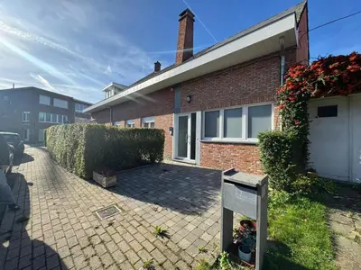 a brick house with a parking meter in front of it at WelKom Studios in Zaventem