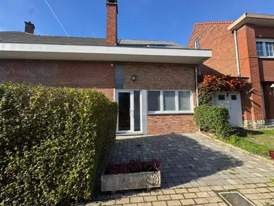 a brick house with a hedge in front of it at WelKom Studios in Zaventem