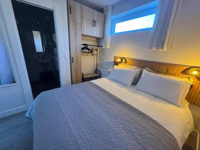 a bedroom with a bed with white pillows and a window at WelKom Studios in Zaventem