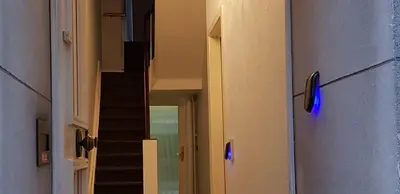 a hallway with a staircase with a blue light on the door at Albert 2 - Basic Room in Mechelen