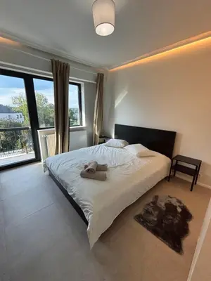 a bedroom with a bed with two towels on it at Luxury 1 Bedroom Apartment with Sofa Bed & Balconies Prime Location near ING Arena, Expo 12 & Atomium in Wemmel