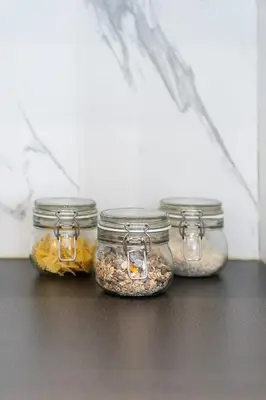 four glass jars filled with different types of food at A Marbled Touched Haven in Antwerp
